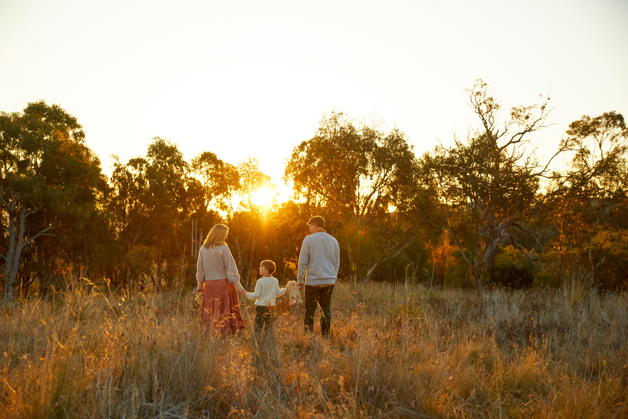Family standing in the Canberran country holding hands
